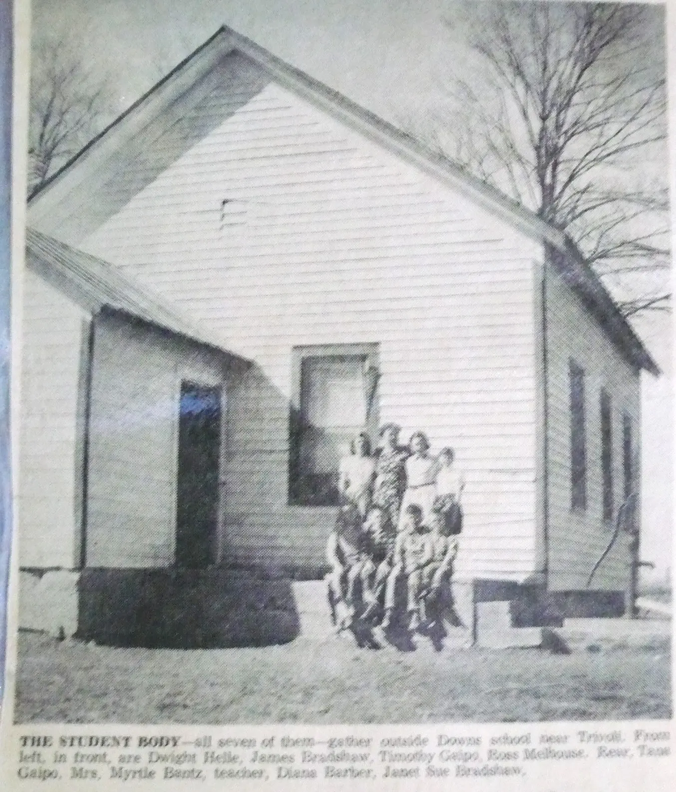 The student body-all seven of them-gather outside Downs School near Trivoli. From left, in front, are Dwight Helle (?), James Bradshaw, Timothy Gaipo, Ross Melhouse, Rear, Tana Gaipo, Mrs. Myrtle Bantz, teacher, Diana Barber (Bamber), Janet Sue Bradshaw