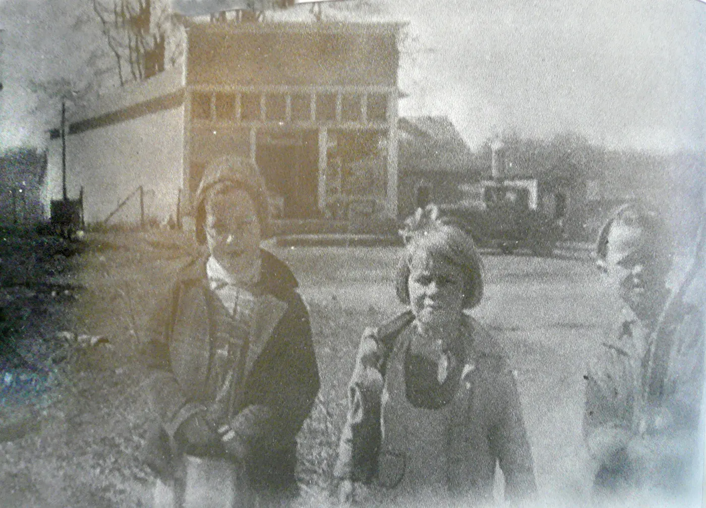 Three little girls standing in front of the store in Northampton